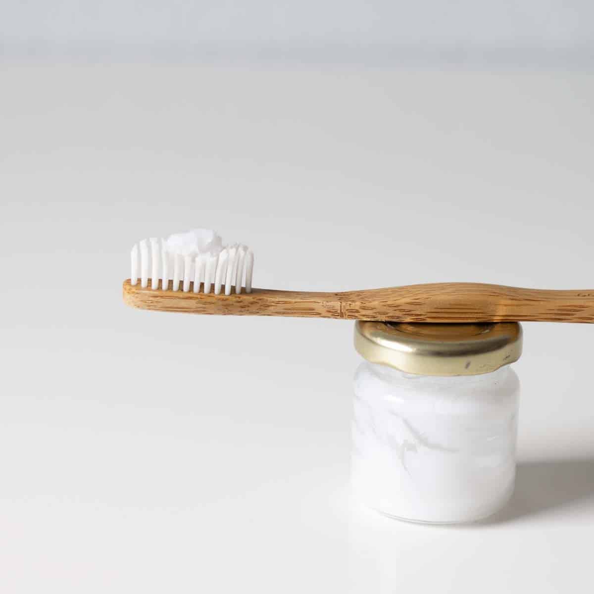Bambuszahnbürste mit einem Klacks selbstgemachter Zahnpasta auf den Bürsten