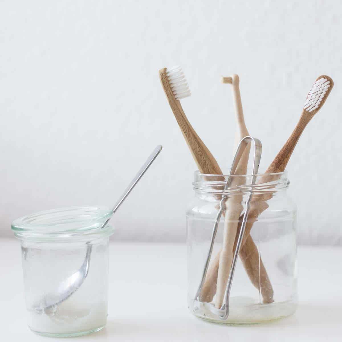 Selbstgemachte Zahnpasta und Bambuszahnbürsten im Glas
